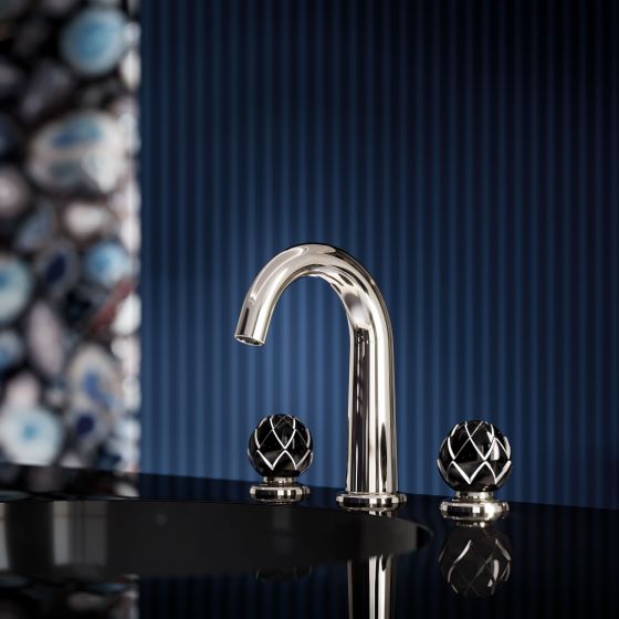 The Belledor tap is nobly shining in silver nickel and looks elegant and festive on a black washstand against a midnight blue background. Its flower-shaped handles are made of black porcelain, decorated with shimmering platinum painting.